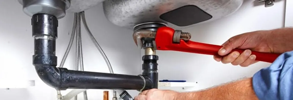 Garbage disposal repair technician tightening the sink drain and disposal connection in Madison, WI